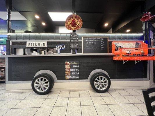 The cute food truck in the interior with the salsa bar.