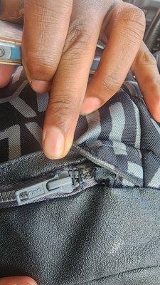 Zipper sewn on backwards, and you can see how it was secured with thread.