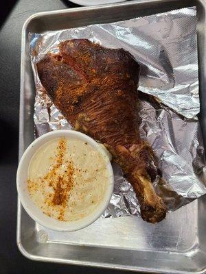 Turkey leg with sauce on the side.