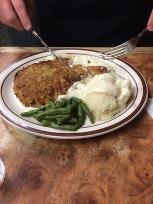 Chicken fried steak with mashed potatoes and white gravy.