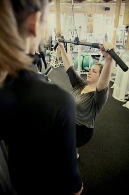 One on one client executes a lat pull down.