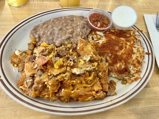 Chilaquiles with tri-tip, refried beans and hash browns