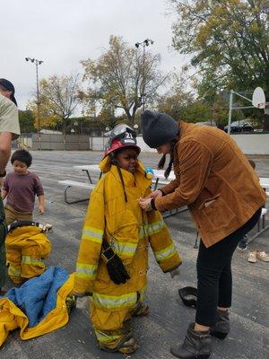 Smokey visited the school and the students got to try on a firefighter's uniform