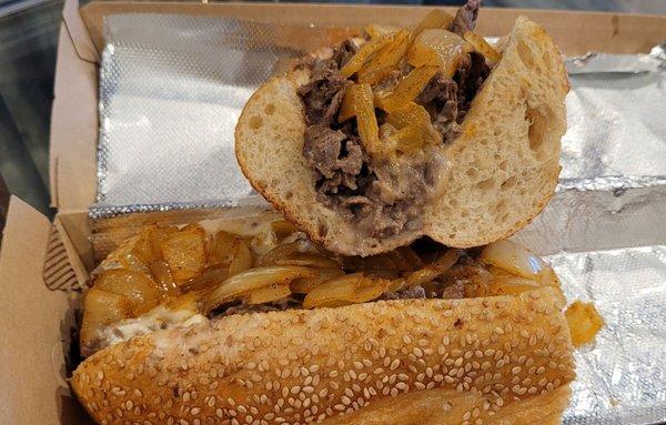 Cheesesteaks, piled high with meat and fried onions.