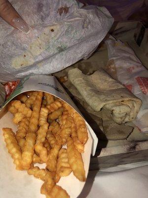 Double dipped non fresh fries and a microwaved burrito with paper stuck to the tortilla