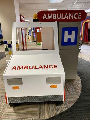 The interactive display includes medical emergency props that simulate an ambulance.