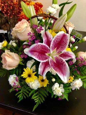 Beautiful basket arrangement of lilies, roses, mini carnations, vikings, and wax flower.