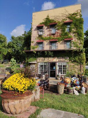 Three story old brick building façade with plants and Talavera pottery.