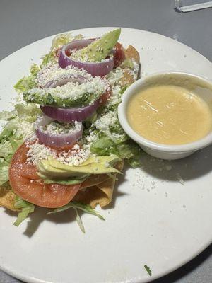 Chicken Taquito topped with sour cream,lettuce, tomato, onion , and avocado with a side of cheese sauce!