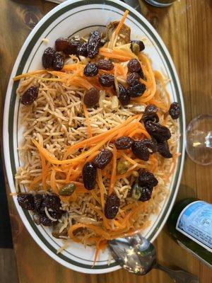 Qabuli Palow Special Traditional Afghan brown rice over Lamb shank topped with raisins and carrots served with salad