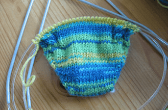 A knitted sock, being worked on 2 circular needles