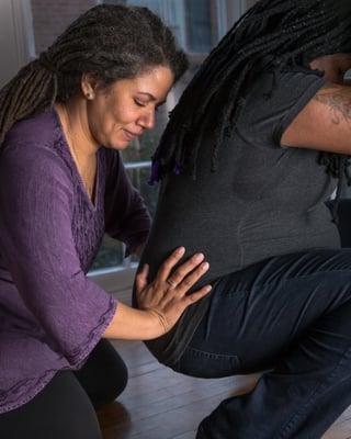 Owner and Doula Melanie demonstrates comfort measures to help support a birthing mother