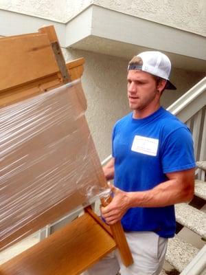 Luke working hard as he brings furniture down the stairs.