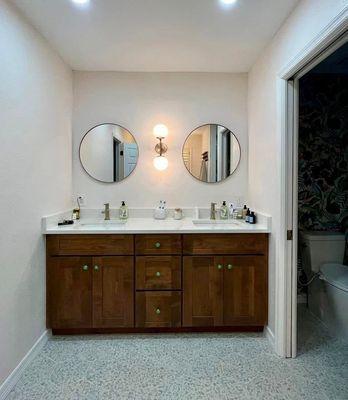 Sophisticated & stylish!  This bathroom remodel boasts a modern vanity, sleek countertops, and beautiful tile flooring.