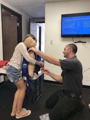 Mr. Plummer training students in how to respond when someone is choking.