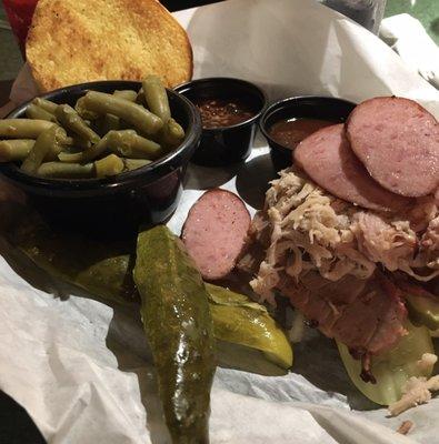 The Pigman sandwich includes sausage, brisket, and pulled pork plus a side.