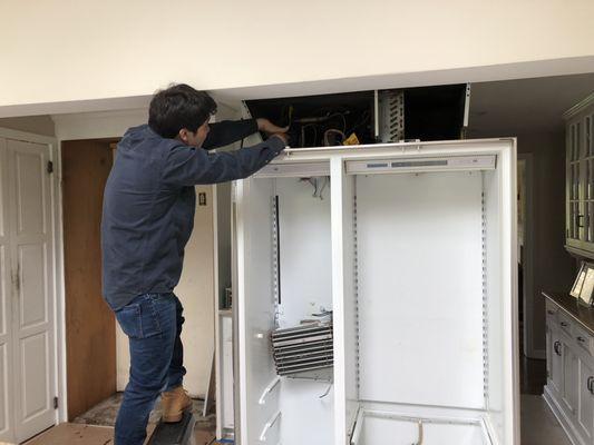 Jonathan dismantles the old freezer system.