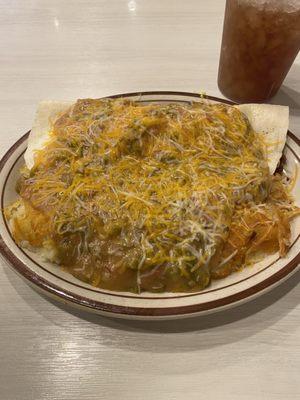 Bacon breakfast burrito smothered in Green Chili served with smothered hashbrowns