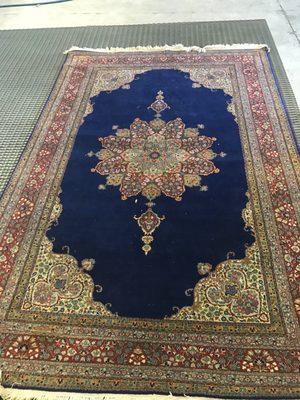 Very nice oriental rug being inspected.