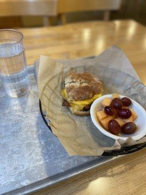 Herbed bread with eggs and bacon with a side of fruit