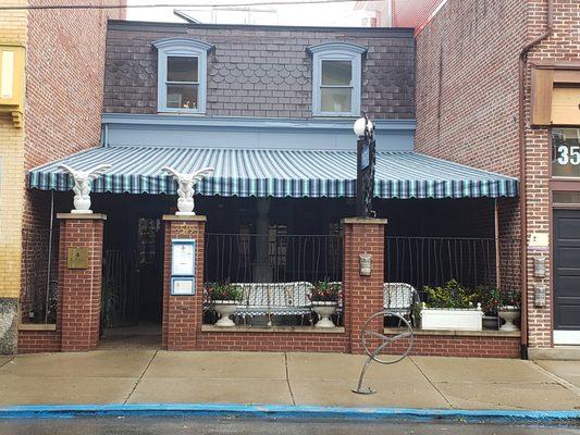 Stationary awning over an outdoor seating area at a restaurant.