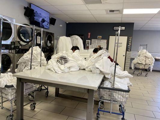 Busy on their phones, not tending to towels in the dryers that are already complete. Making other customers wait. Classless.