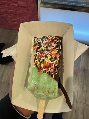 Pistachio ice cream dipped in chocolate and sprinkle