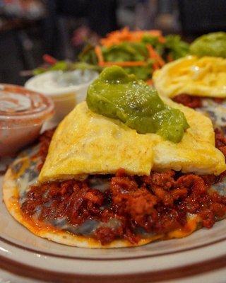 La Mexicana  two flour tortilla, topped with black beans, Mexican  three beans, home made cherizo, scramble eggs and guacamole