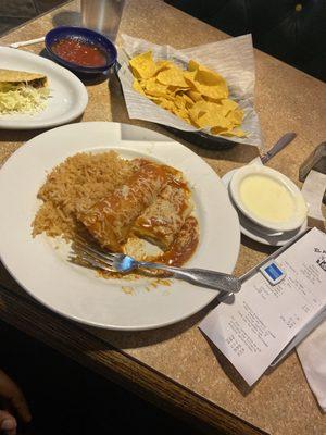 Cheese and chicken Enchiladas. See how receipt is there and food is still on table?