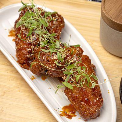 Crispy jumbo wings coated in gochujang, sesame seeds, and scallions.