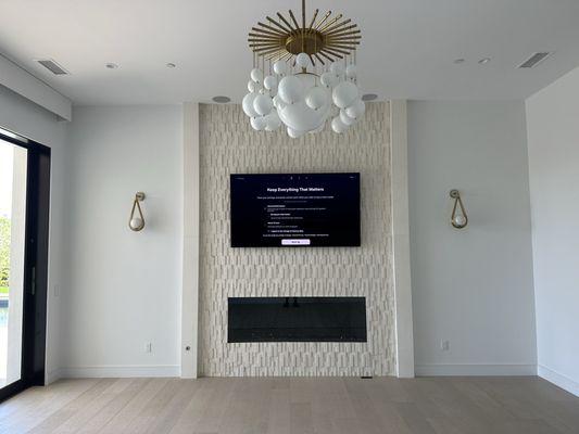 Installation of an 85" Samsung OLED TV above a gas fireplace in the master bedroom.