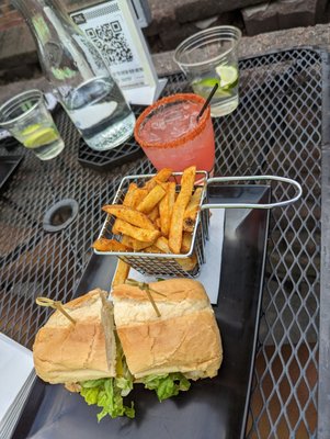 Fried fish sandwich, fries, and watermelon margarita