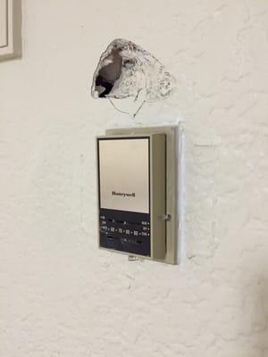 Hole in wall by thermostat