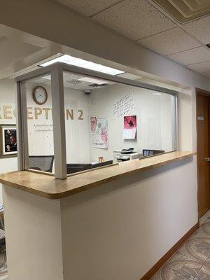 Custom glass guard installed at a reception desk.