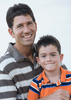 A father with healthy teeth holding his son