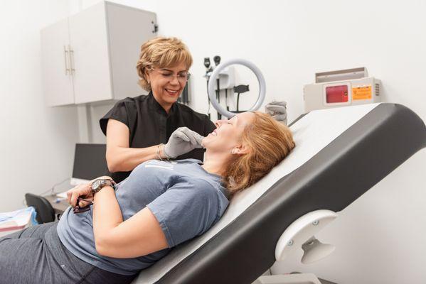 "In the image, a client is comfortably reclined in a modern, well-lit treatment room. The client is being prepared for a PRP session.