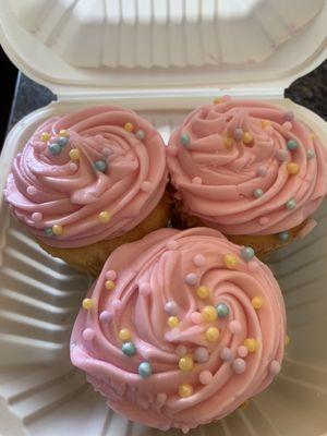 Delicious butter cupcakes with pink vanilla butter cream frosting with candy pearls