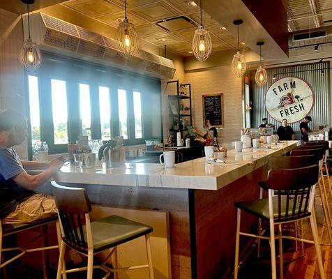 The indoor bar opens to serve outdoor guests on the sidewalk dining area.