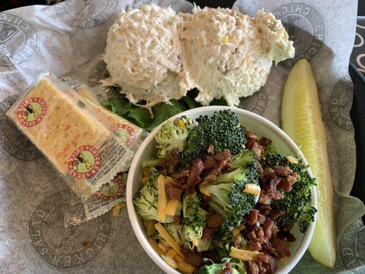 Two scoops of chicken salad and side of broccoli salad.