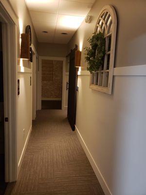 Hallway leading to couples room, additional treatment room, and sauna.