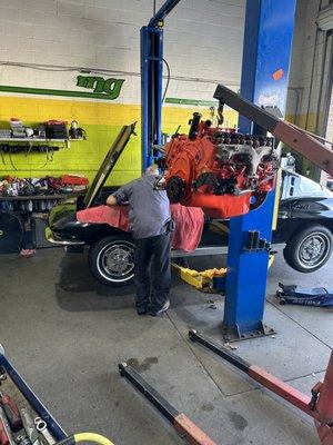 63 Corvette getting its fully rebuilt engine being installed back in its place.