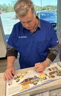 Dr. Weaver autographing one of the Porter and Midge books he is featured in.