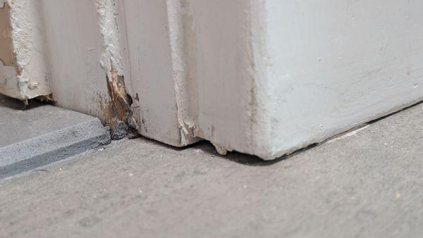 Bottom of door with the holes and chipped wood