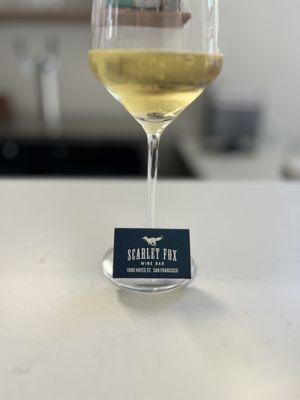 Glass of white wine with a book of matches branded with the Scarlet Fox logo