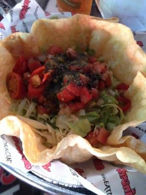 Tostada bowl with Carnitas and Carne Asada buried beneath all that lettuce and jalapeños