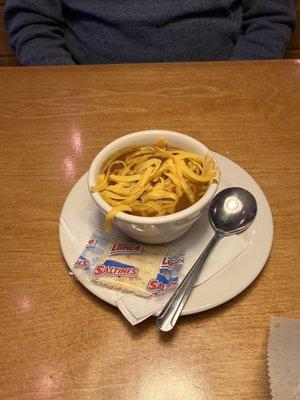 Cup of chili with cheese and crackers