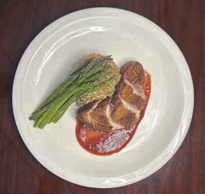 Pan seared duck breast with mushroom herb risotto, roasted asparagus and a cherry gastrique.