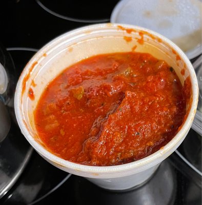 Cup of marinara sauce that comes with pasta dishes, takeaway