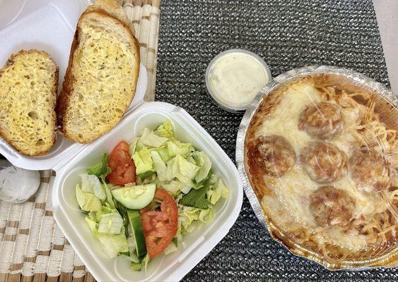 Spaghetti and meatballs with side salad and garlic bread