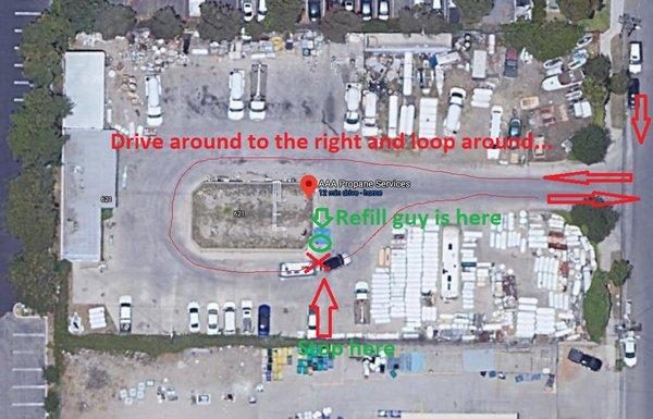 Stop where indicated, get out of the car and bring out your tank(s) for refilling.  The guy will either be there, or see you and come over.